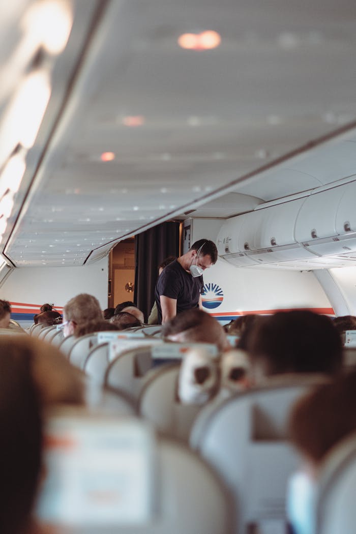 A traveler wearing a face mask in an airplane cabin, embracing new safety norms.